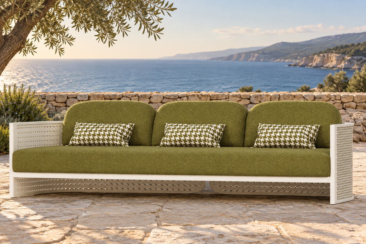 Lifestyle view: Luna Sofa in Aluminium with olive upholstery and three houndstooth pillows overlooking a coastal bay