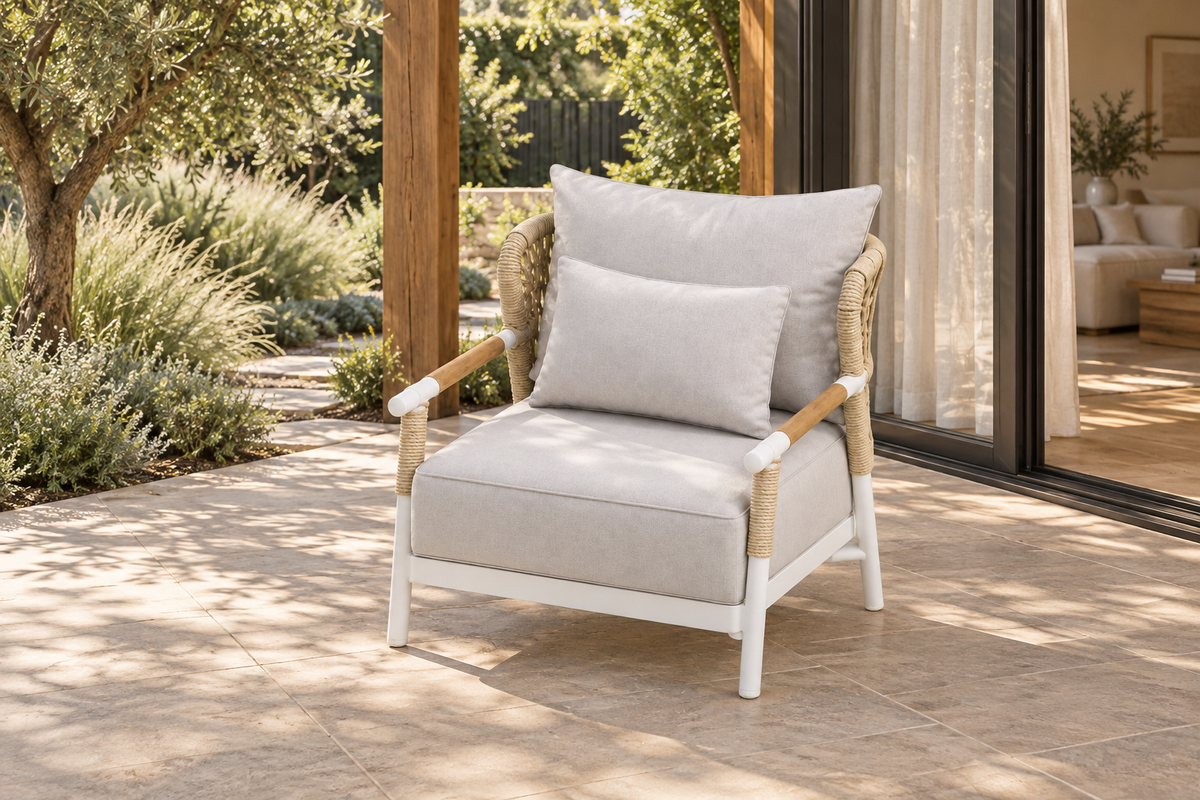 Lifestyle view: Vela aluminium lounge chair on a planted terrace beside a furnished home.