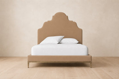 Camilla Upholstered Bed — Aged Brass, photographed in a quiet bedroom