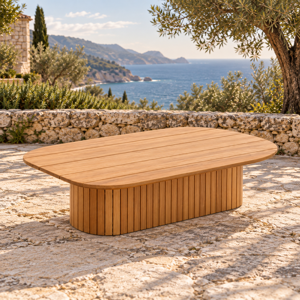 Lifestyle view: Ethereal Coffee Table in Teak, opposite three-quarter view on a coastal stone terrace