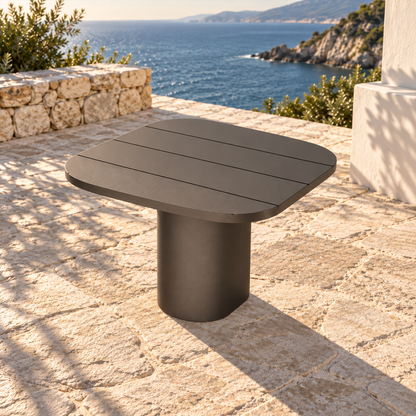 Lifestyle view: Ethereal Side Table in Aluminium, elevated diagonal view on a coastal stone terrace