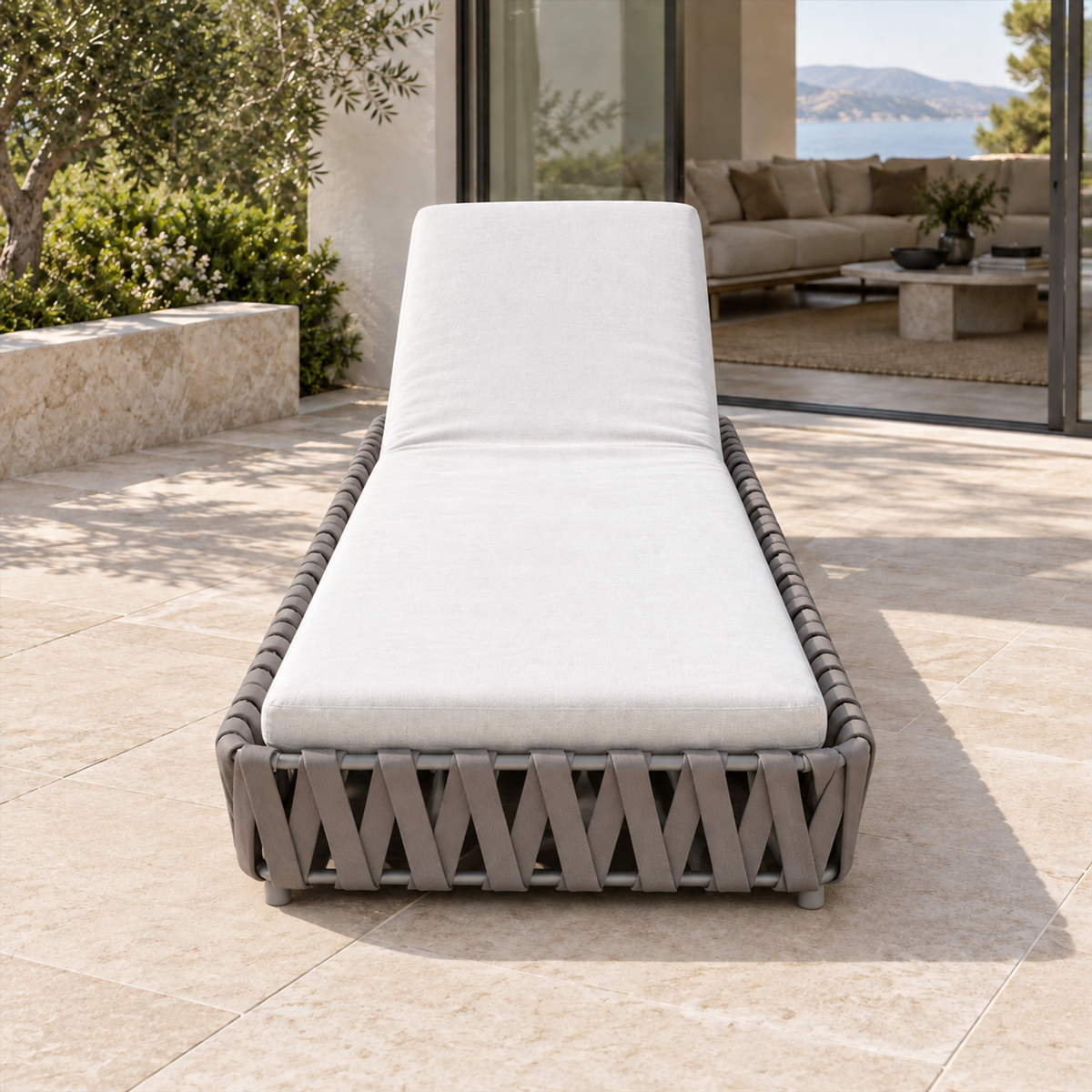 Lifestyle view: Linosa grey strap-woven sun lounger photographed beside a limestone pool