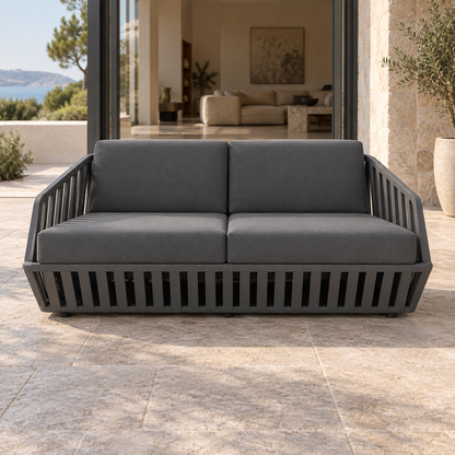 Lifestyle view: Mykonos Two-Seat Sofa, photographed in a quiet outdoor courtyard