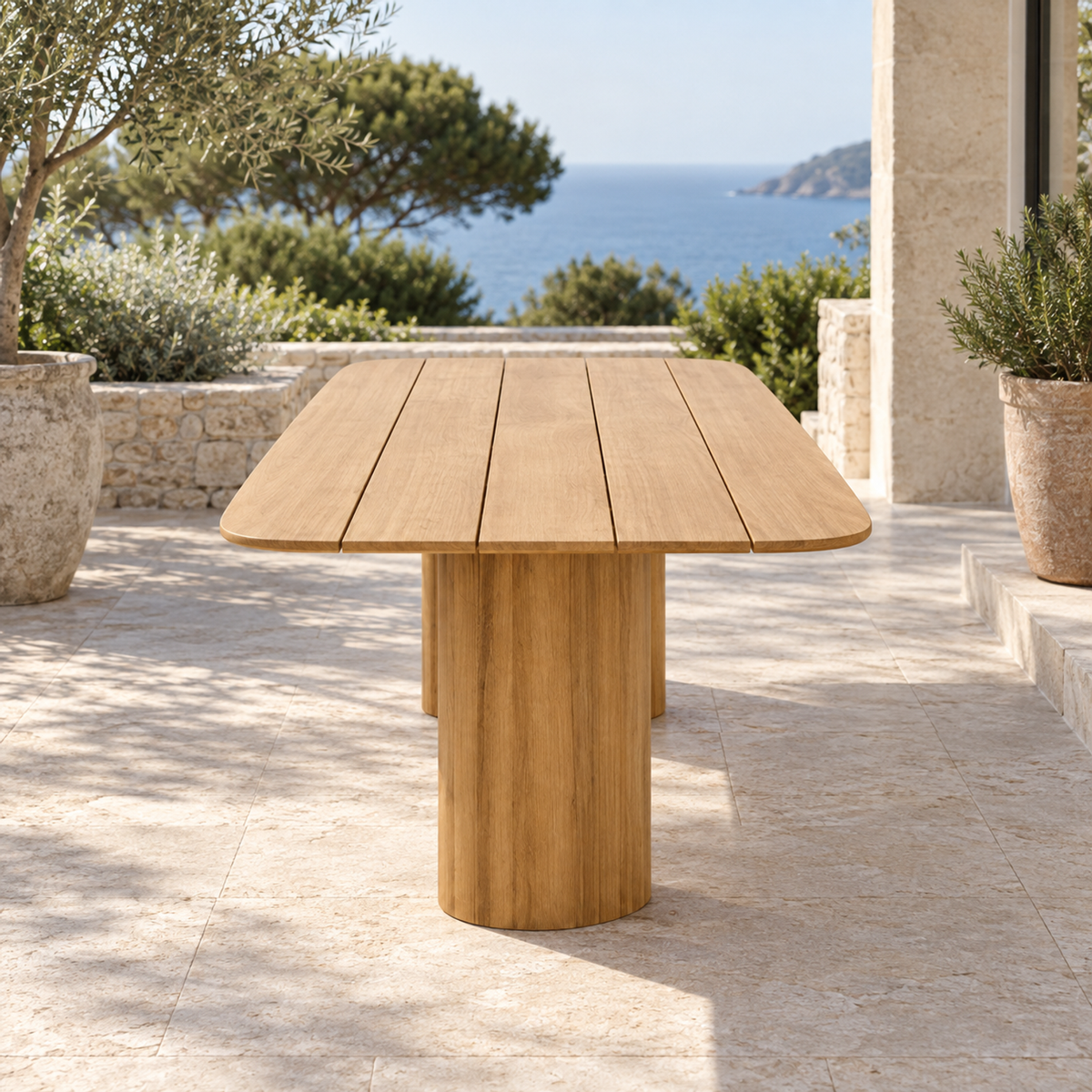 Lifestyle view: Ripple Dining Table in Teak, short-end view on a coastal terrace