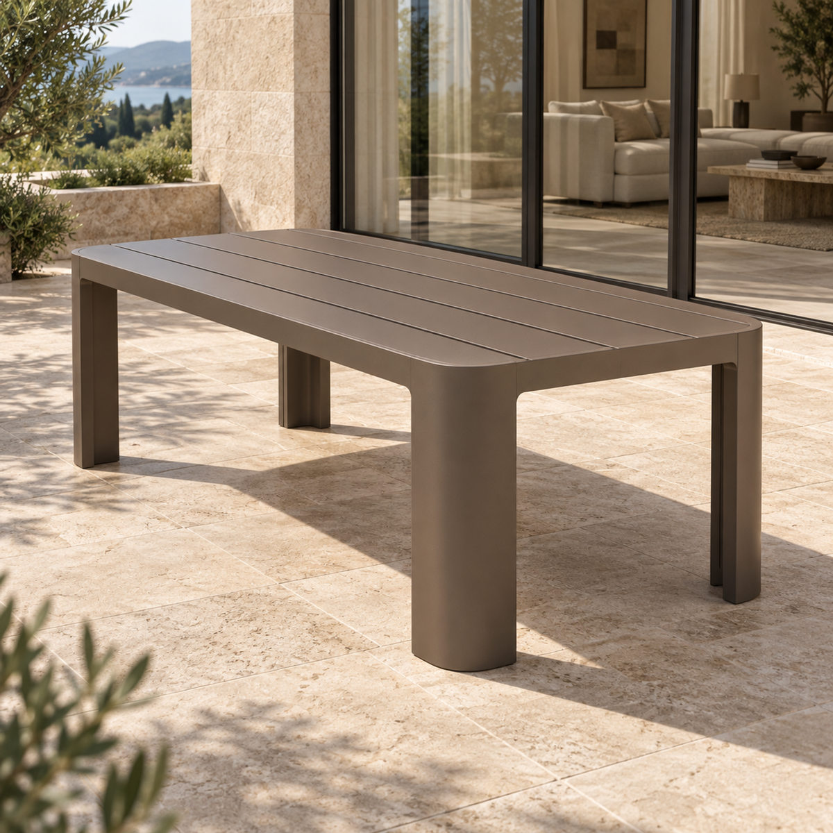 Lifestyle view: Serein aluminium dining table beside a planted garden and furnished home