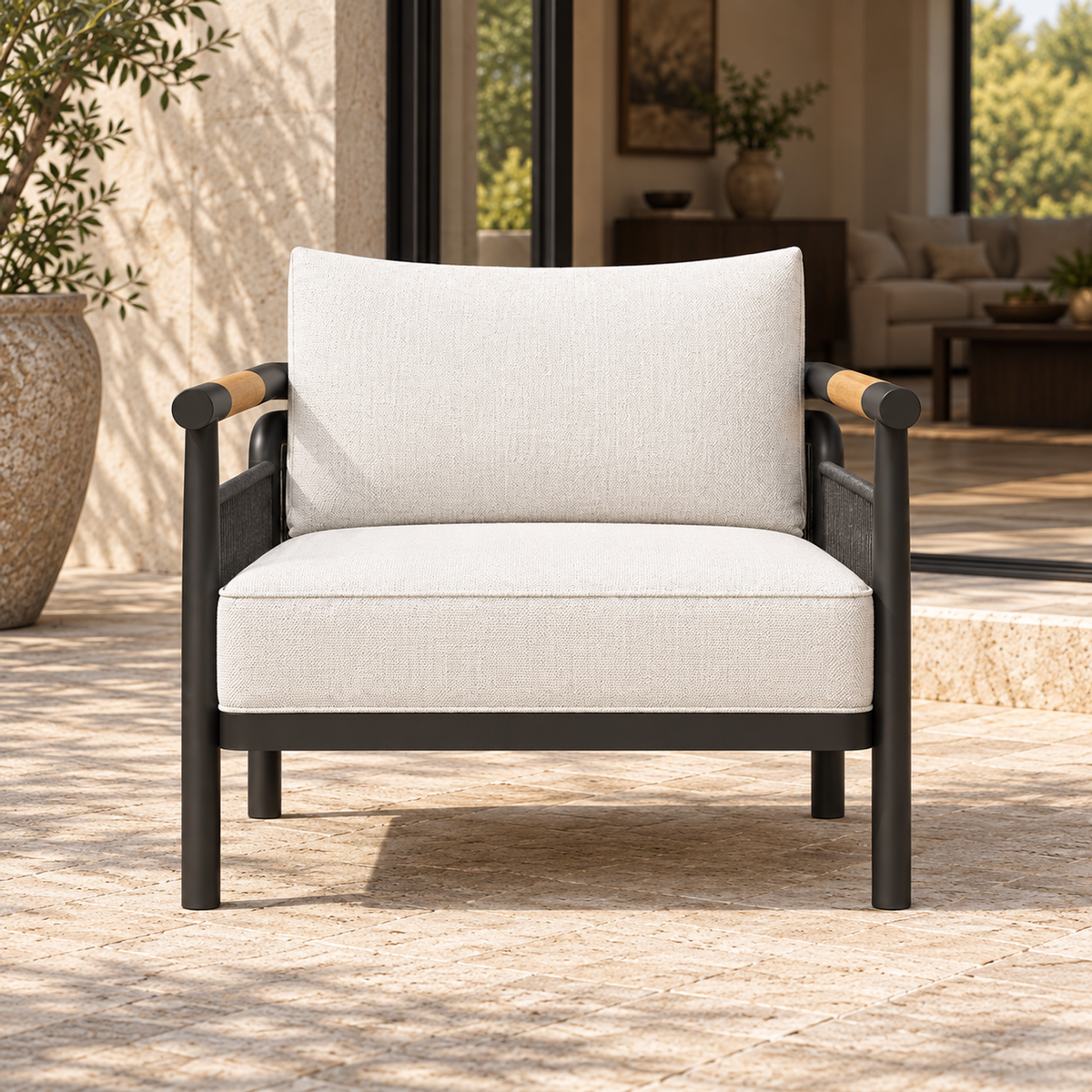 Zenia aluminium lounge chair, straight front view beside a furnished home